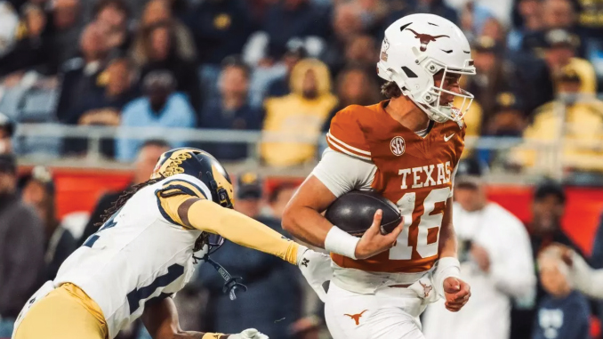 Texas Longhorns player carrying the football and dodging a tackle from a defender in navy and gold inside a crowded stadium