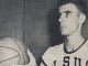 Young man in a USA basketball jersey holding a basketball and looking to the right.