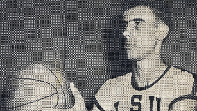 Young man in a USA basketball jersey holding a basketball and looking to the right.