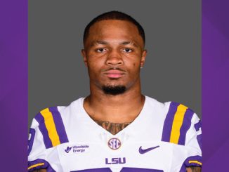 Portrait of an LSU Tigers football player wearing a purple and gold jersey, facing the camera with a neutral expression.