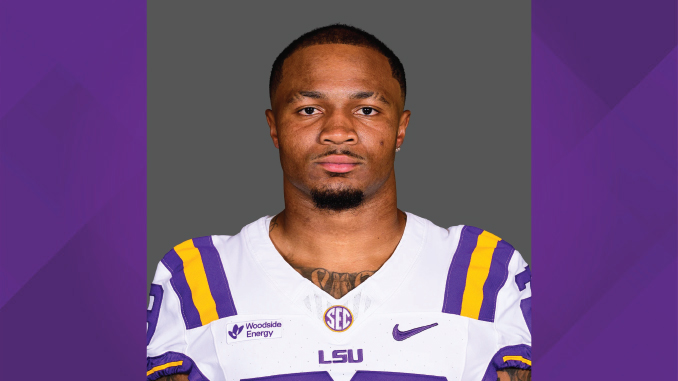 Portrait of an LSU Tigers football player wearing a purple and gold jersey, facing the camera with a neutral expression.