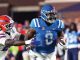 Ole Miss Rebels player in blue jersey carries the football, pursued by a Florida Gators defender in white.