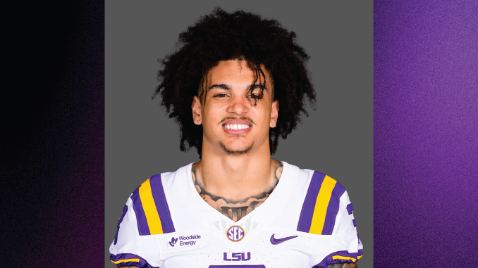 Portrait of a college football player wearing an LSU purple and gold jersey against a gray background.