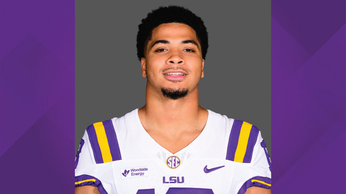 Athlete in LSU football jersey facing camera, gray background.