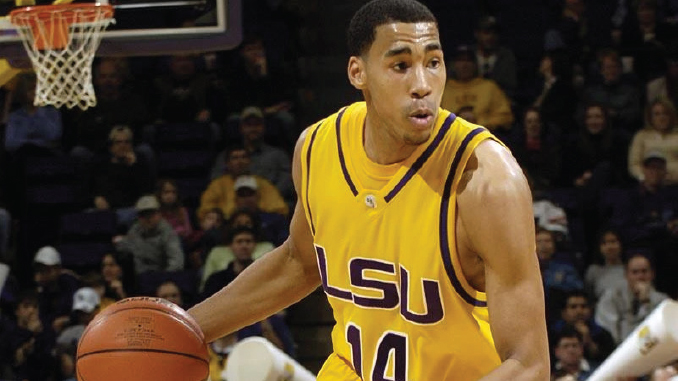 GarrettTemple_LSUAthletics | TigerRag.com LSU basketball player wearing number 14 dribbles with the ball during a game, gym crowd in the background.