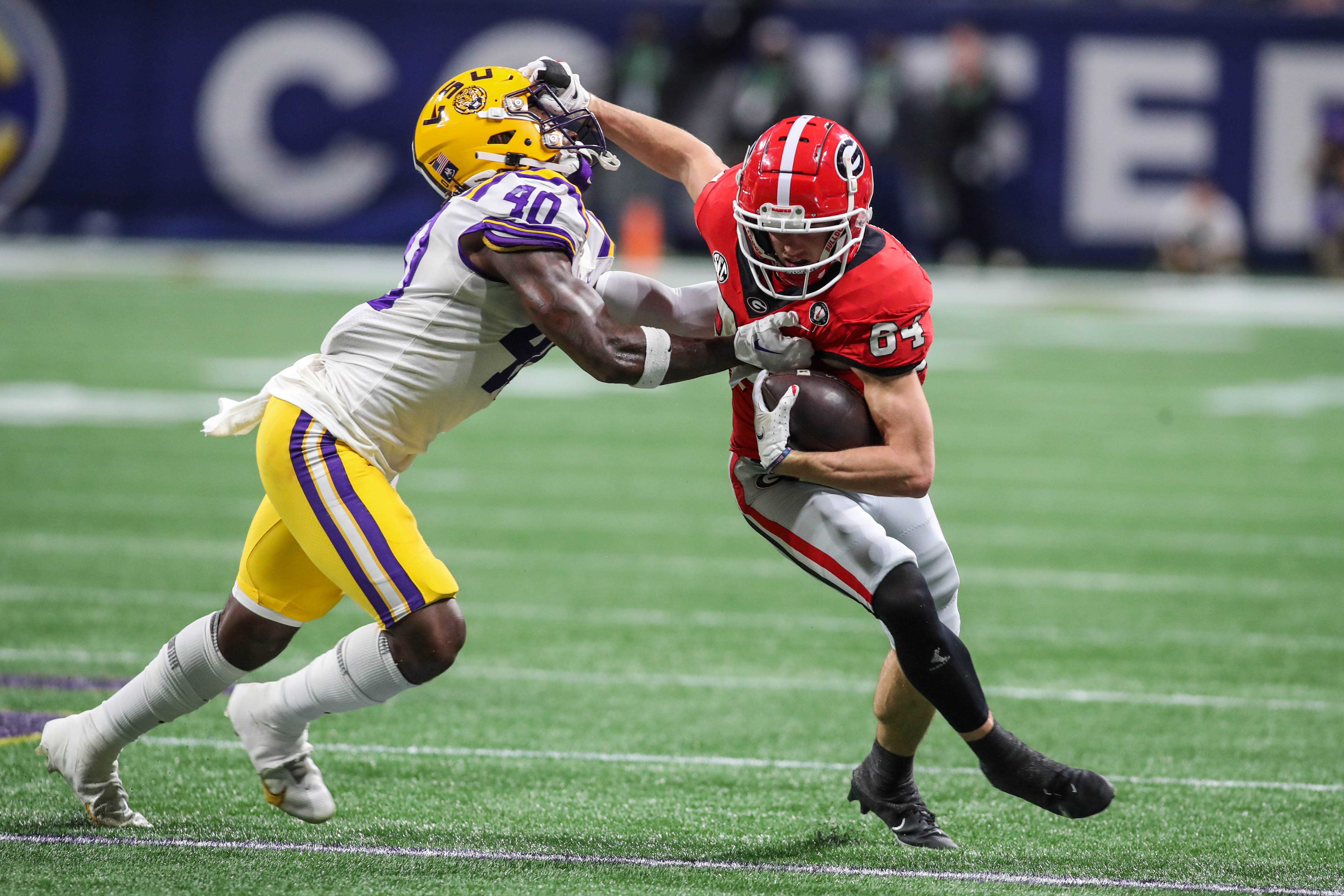 Georgia's Ladd McConkey (84) stiff-arms LSU's Harold Perkins (40).