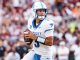 Kentucky quarterback in white and blue jersey #3 holding the football and looking downfield during a game.