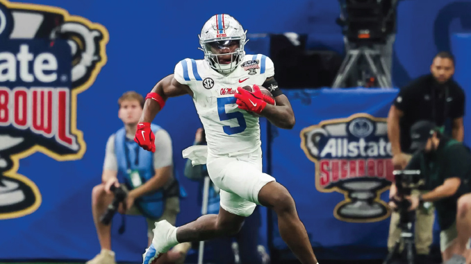 Football player in white and blue uniform sprinting with the ball during a Sugar Bowl game