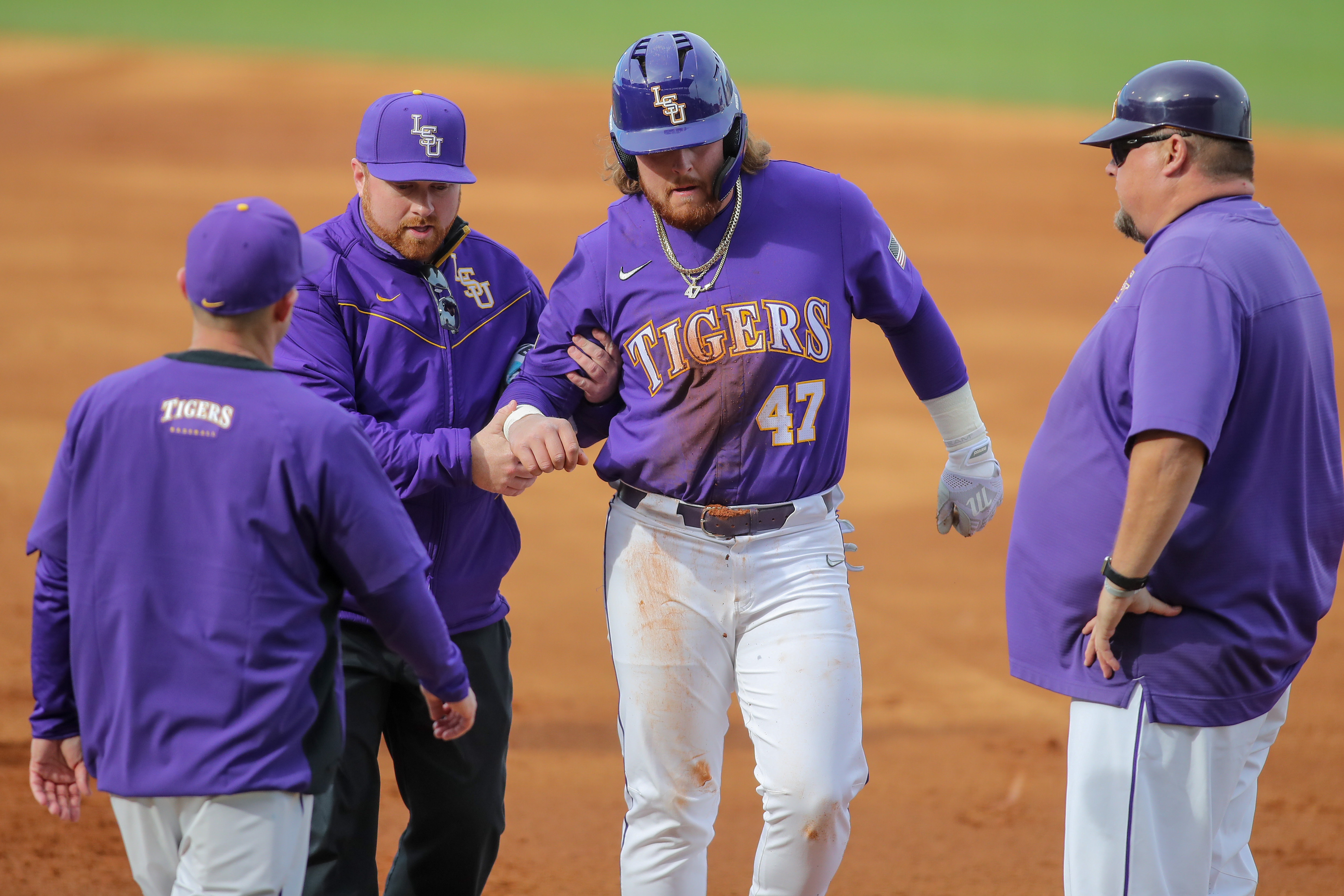 Tommy White leaves LSU's season-opener in the first inning after sustaining an injury of unknown severity after diving back to first safely during a pick-off attempt. Photo by Jonathan Mailhe