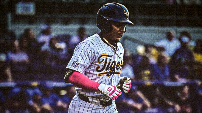 Baseball player in a white pinstripe Tigers uniform with pink sleeves, wearing a helmet and running on the field with a crowd in the stands behind.