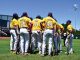 Huddle of baseball players in yellow uniforms on the field, backs visible with names and numbers 25, 33, 44, facing inward for a team discussion