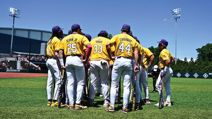 Huddle of baseball players in yellow uniforms on the field, backs visible with names and numbers 25, 33, 44, facing inward for a team discussion