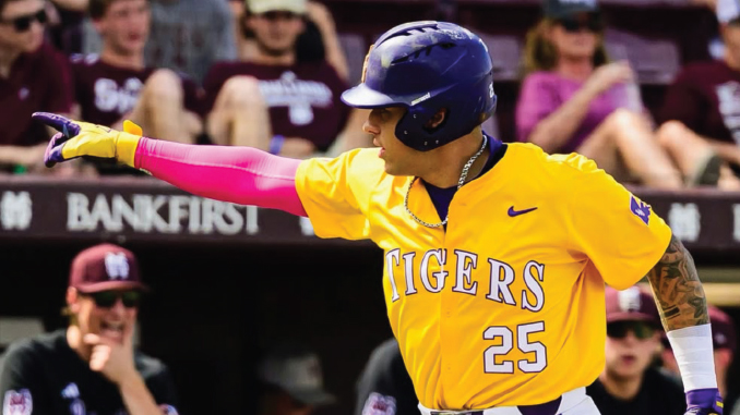 Baseball player in a yellow Tigers jersey with number 25, helmet on, pointing with his left arm during a game.