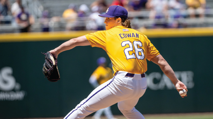 Baseball pitcher in a yellow jersey with 'COWAN' and number 26 throws a pitch on the mound, glove raised left, ball in right hand