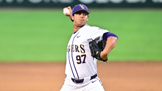 Baseball pitcher in a white and purple uniform, number 97, mid-pitch on the mound with glove ready and ball released.