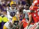 LSU football: quarterback #10 in white drops back to pass amid red-clad defense and a blocking teammate nearby.