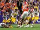 College football action: Clemson player in orange (#16) leaps over LSU defenders on the green turf with a crowded stadium in the background.