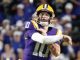 American football quarterback in purple and gold uniform throwing a pass during a game in front of a cheering crowd.