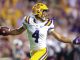 LSU quarterback wearing #4 in a white and purple uniform throws a pass on the field.