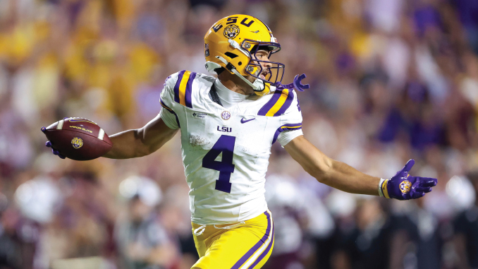LSU quarterback wearing #4 in a white and purple uniform throws a pass on the field.