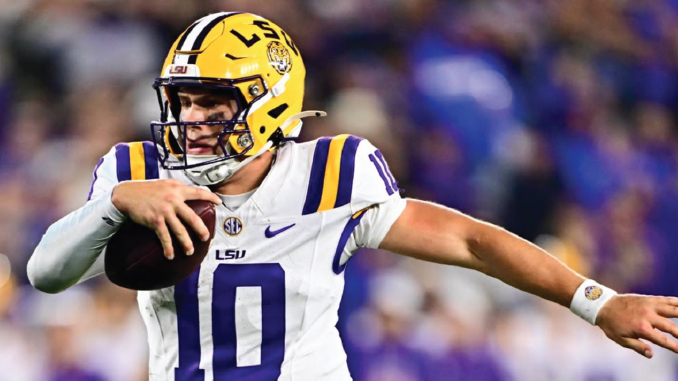 LSU quarterback wearing number 10 runs with a football in a white and purple uniform during a game.