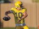 Quarterback in yellow uniform (#10) about to throw a football during practice on a grassy field.