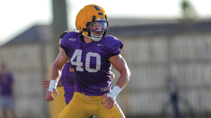 LSU football player wearing purple jersey #40 and a yellow helmet, mid-action on a practice field.