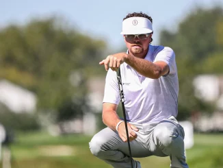 Golfer in a white visor crouching with a putter on a sunny golf course.