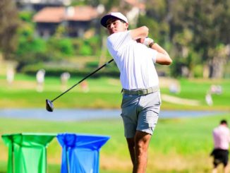 Golfer in white shirt and cap mid-swing on a sunny golf course.