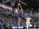 Basketball player in blue and gold (No. 99) dunks the ball over a defender while a full arena watches.