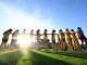 Women soccer players in yellow uniforms form a line on the field, holding hands before a game, bright sun and blue sky.