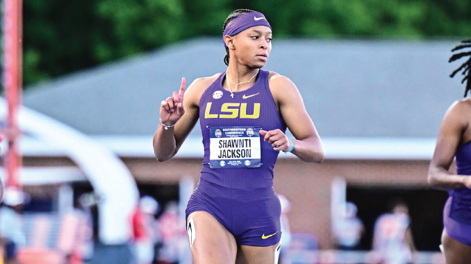 LSU track sprinter in a purple uniform and headband racing on an outdoor track, bib reads Shawnti Jackson.