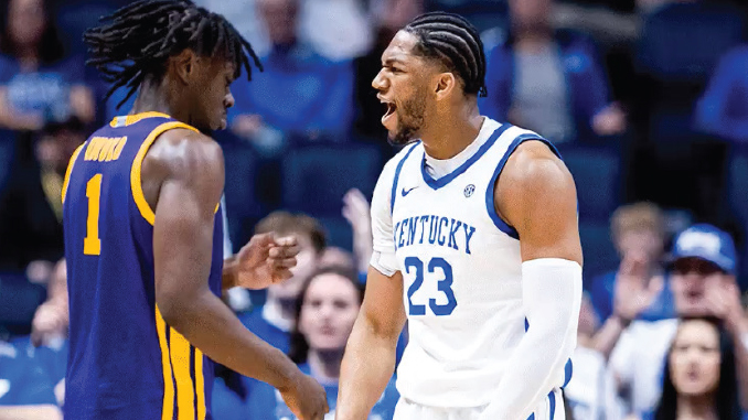Kentucky player #23 in white jersey confronts a purple-uniform opponent during a heated basketball moment.