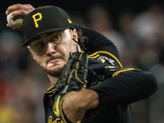 Pittsburgh Pirates pitcher mid-pitch in a black and gold uniform, throwing the ball with glove up near his face.