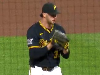 Baseball pitcher in Pirates uniform on the mound, glove up and ready to throw.