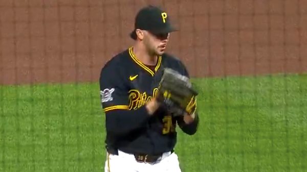 Baseball pitcher in Pirates uniform on the mound, glove up and ready to throw.