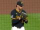 Baseball pitcher in Pirates uniform on the mound, glove up and ready to throw.