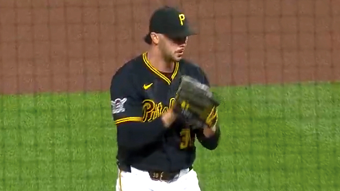 Baseball pitcher in Pirates uniform on the mound, glove up and ready to throw.