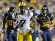 LSU football player in white and purple, wearing #7, sprints with the ball as defenders in navy and gold chase him on the field.