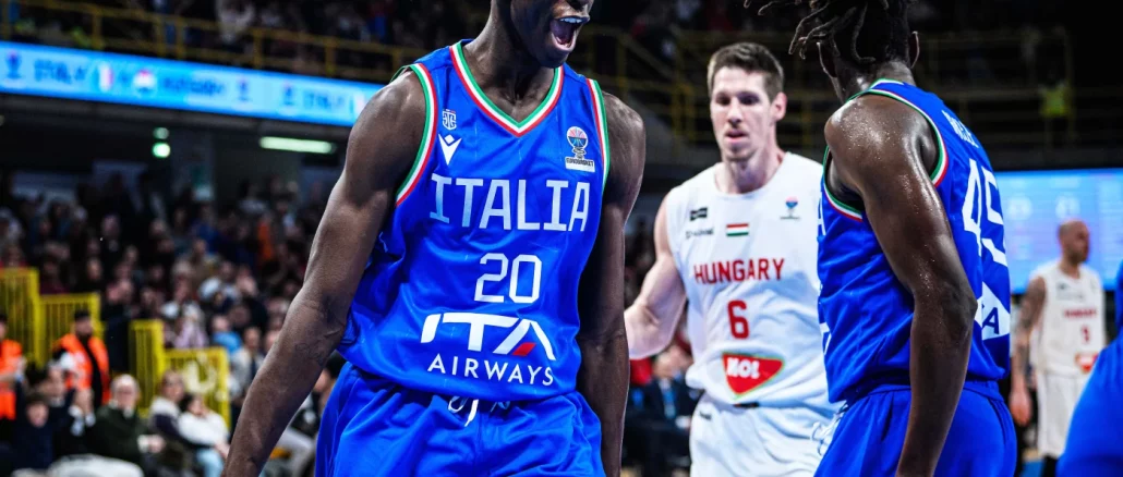 Italy basketball players in blue jerseys celebrate on court during a game, one shouting with fist clenched.