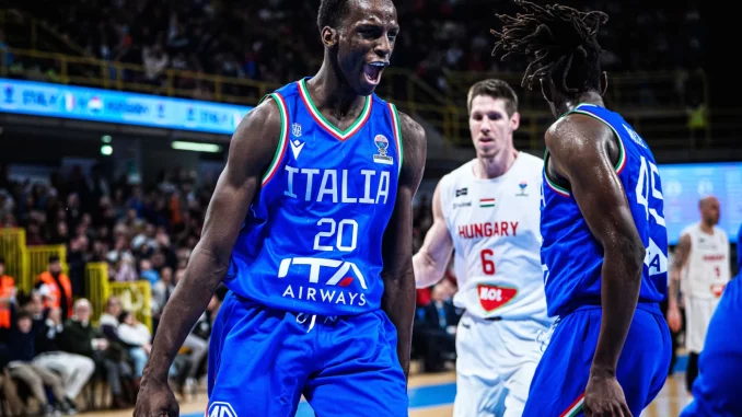 Italy basketball players in blue jerseys celebrate on court during a game, one shouting with fist clenched.