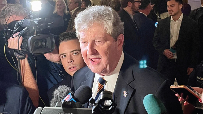 Former U.S. President Bill Clinton speaks to reporters as cameras and microphones surround him at a press event.