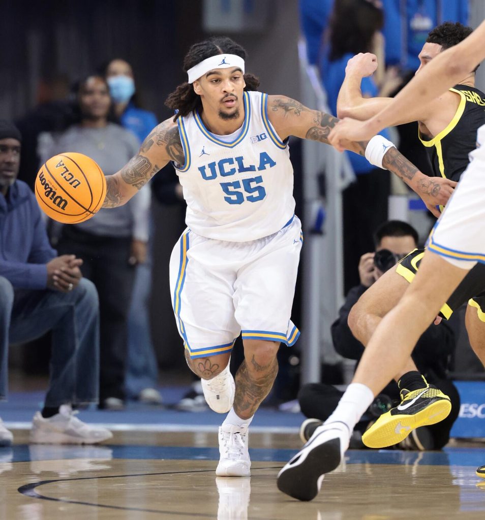 UCLA Oregon NCAA Basketball | TigerRag.com UCLA basketball player #55 dribbles down court, defended by a nearby opponent in a black and yellow uniform.