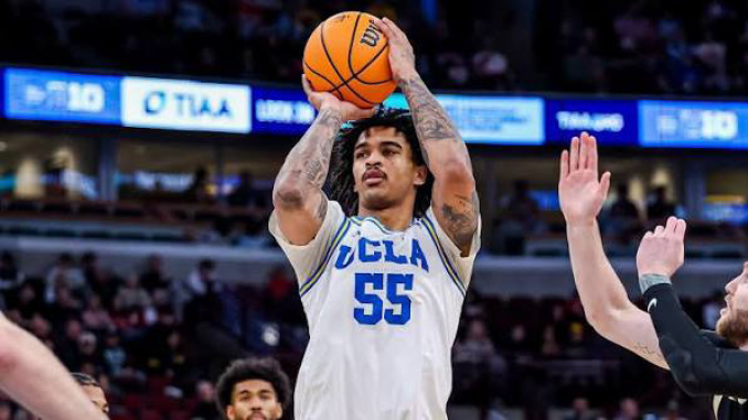 UCLA player in white jersey number 55 shoots a basketball over defenders during a game.