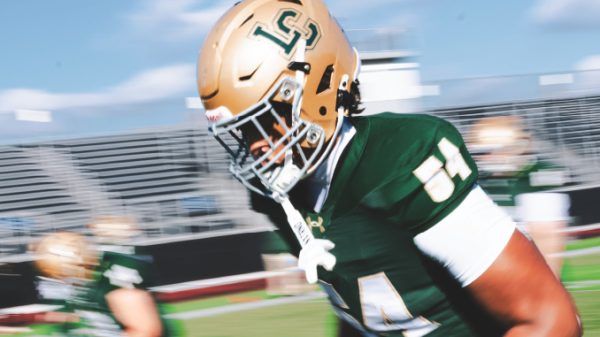 LSU football player in green jersey #81 running on a sunny game field, gold helmet and white gloves visible.